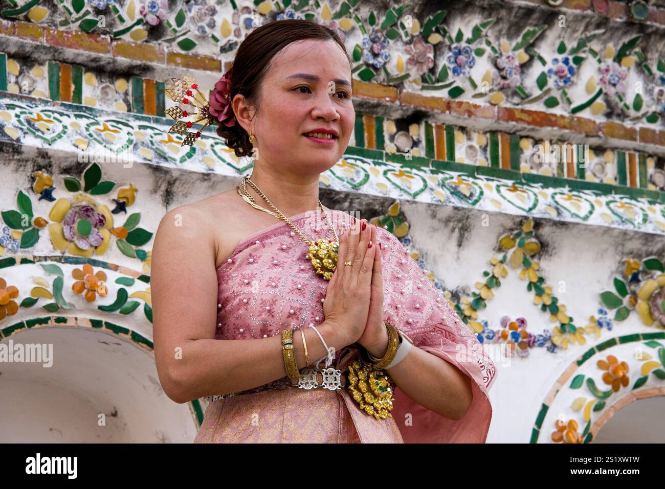 Menschen in traditioneller thailändischer Kleidung feiern den Makha Bucha Day im Wat Arun und zeigen kulturelle Schönheit und Einheit in einer spirituellen und festlichen Atmosphäre. Stockfoto