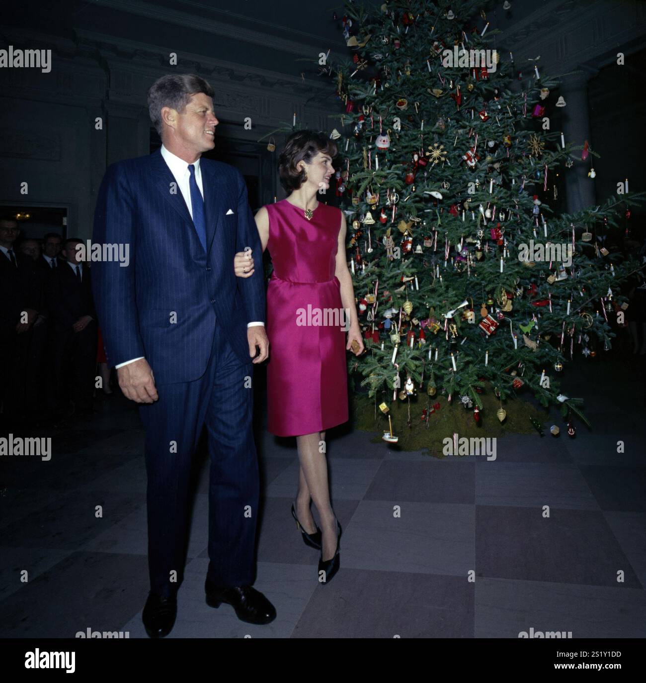 12. Dezember 1962 Präsident und Mrs. Kennedy nehmen am 12. Dezember 1962 an der Staff Christmas Party in der Nähe des Weihnachtsbaums in der Cross Hall Teil. Gescannt von Original 2,25' negativ von LAA DAMS 2B Stockfoto
