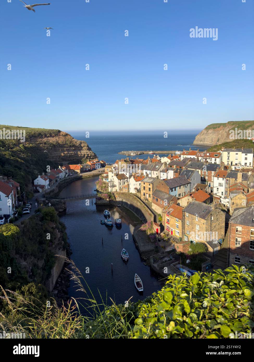 Blick aus der Vogelperspektive auf das Fischerdorf Staithes bei Sonnenuntergang, North Yorkshire, England - Smartphone-aufgenommenes Stockfoto