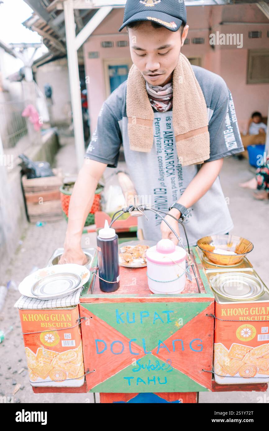 Bogor, 4. Januar 2025. Ein traditioneller Doclang-Anbieter, der seinen Kunden frisch zubereitete Gerichte auf der Straße serviert. Stockfoto