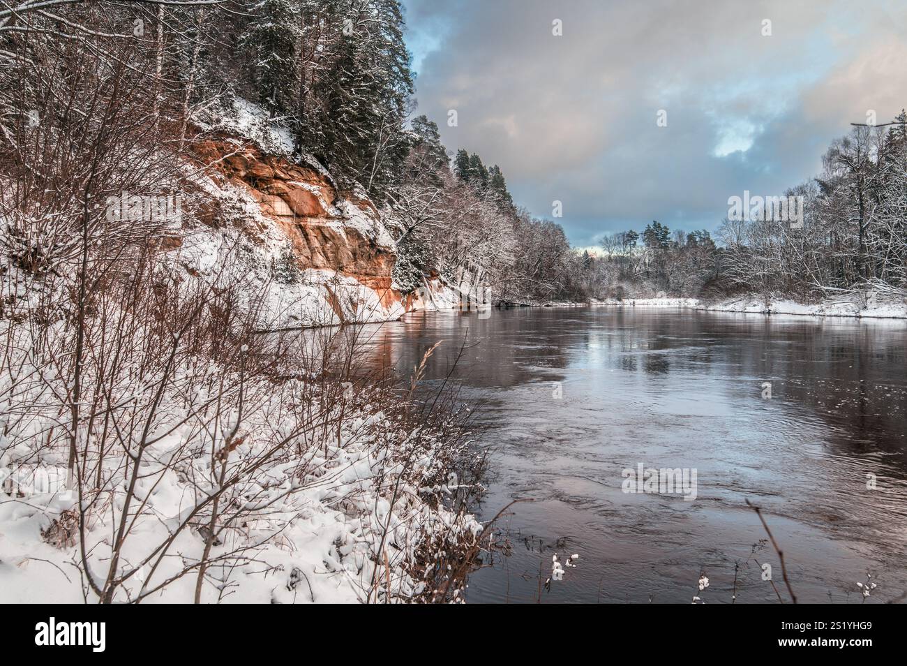 Blick auf die Landschaft der roten Sandsteinhöhlen am Fluss Gauja in Sigulda, Lettland an einem schneebedeckten Wintertag Stockfoto