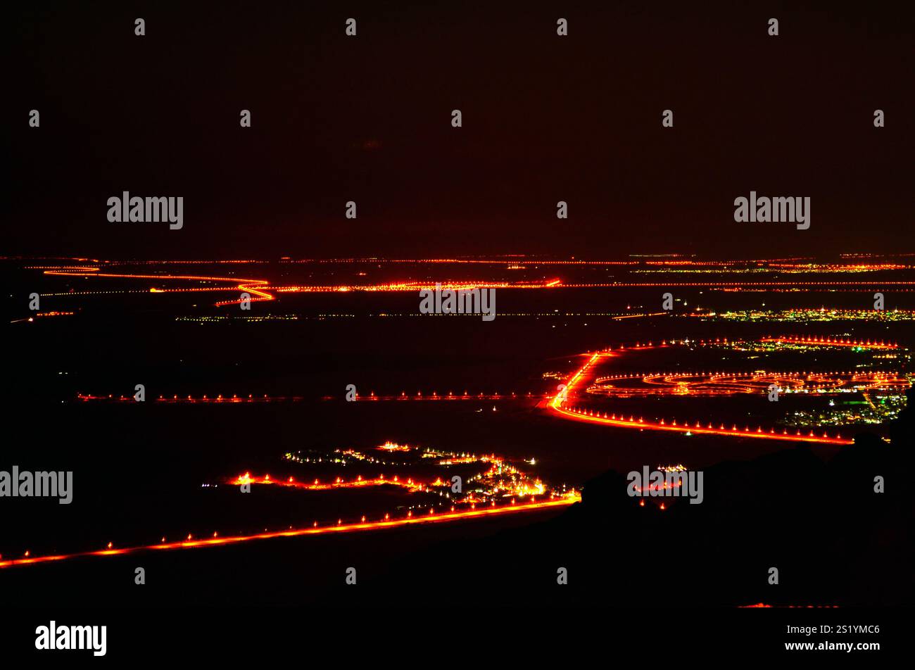 Ein ruhiger Nachtblick von Jebel Hafeet mit Stadtlichtern und Sternenhimmel. Stockfoto