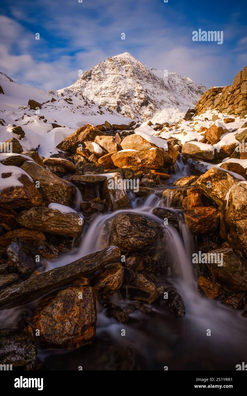 Ein Winterblick auf Snowdon (Yr Wyddfa) von Afon Glaslyn, einem Bach, der den Hügel vom See Glaslyn herunterstürzt, Snowdonia (Eryri), Nordwales Stockfoto