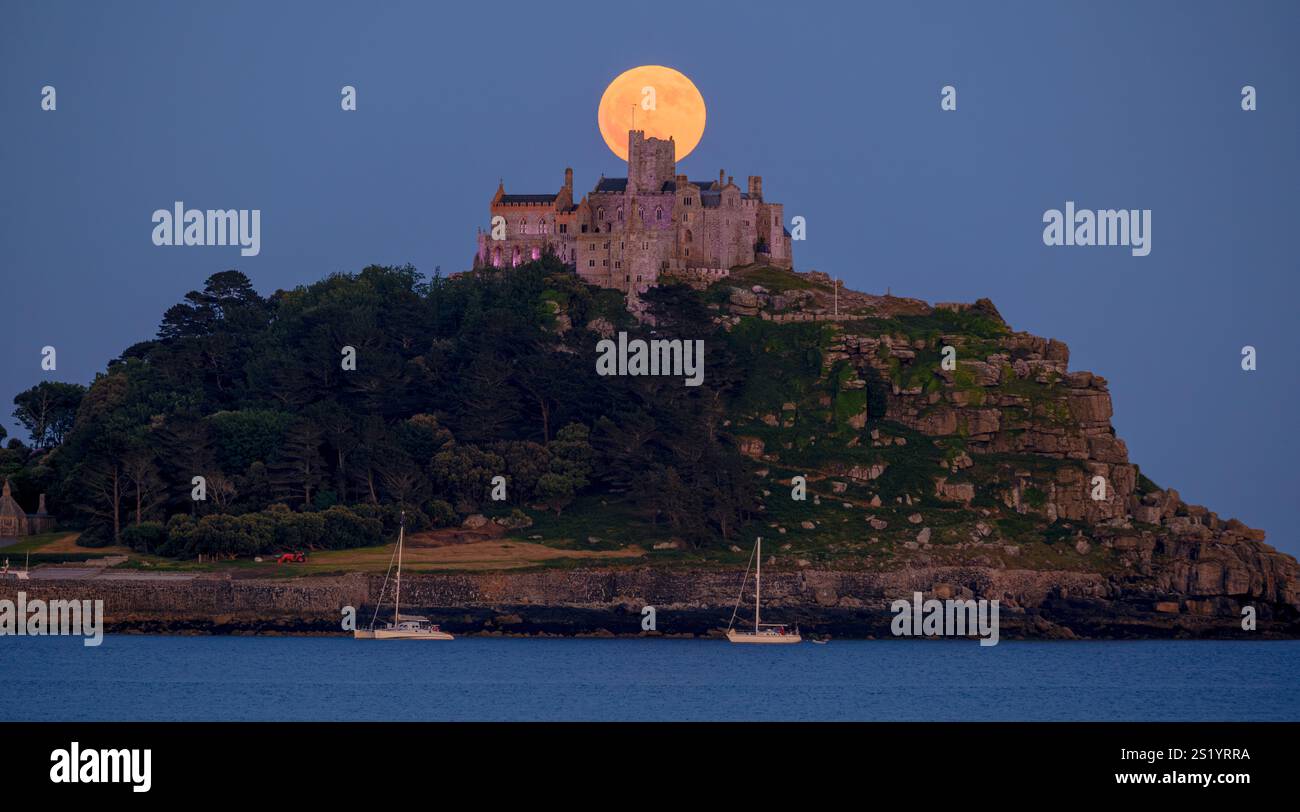 Der volle Strawberry Moon, der hinter St. Michael's Mount in Mounts Bay, Marazion, Cornwall aufsteigt. Stockfoto