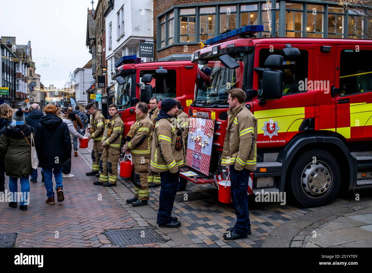 Feuerwehrleute sammeln Geld für die Feuerwehrleute Charity in Christmas, High Street, Canterbury, Kent, Großbritannien. Stockfoto