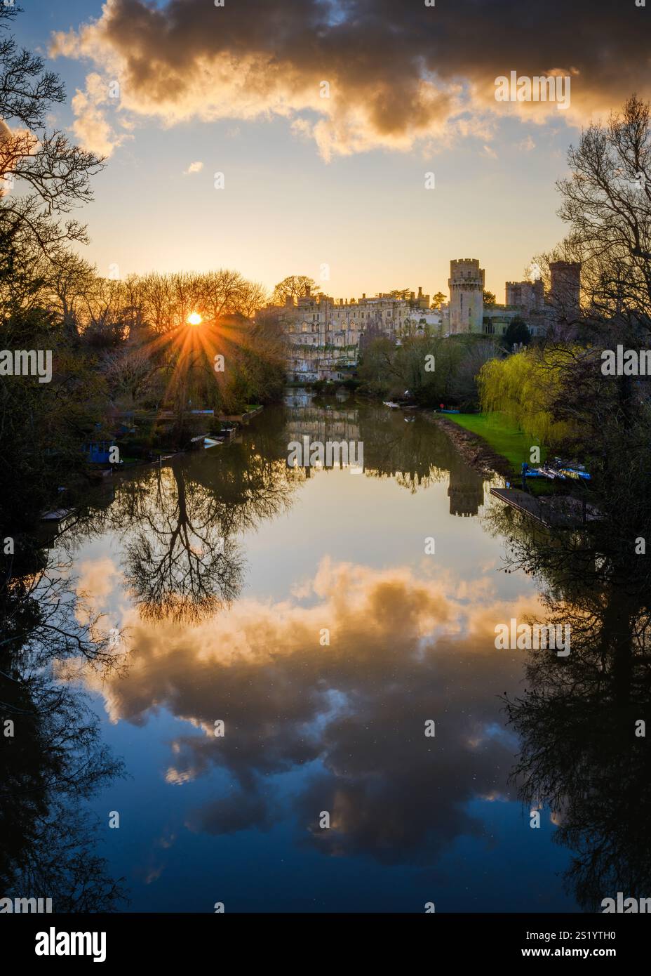 Die untergehende Sonne scheint durch die Bäume am Ufer des Flusses Avon bei Warwick Castle. Stockfoto