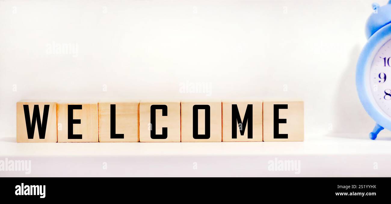Eine Reihe von Holzblöcken, auf denen das Wort „Willkommen“ steht. Begrüßungsgruß für Einladung, ausdrückliche Gastfreundschaft, Begrüßung, Show Akzeptanz. Design für Bu Stockfoto
