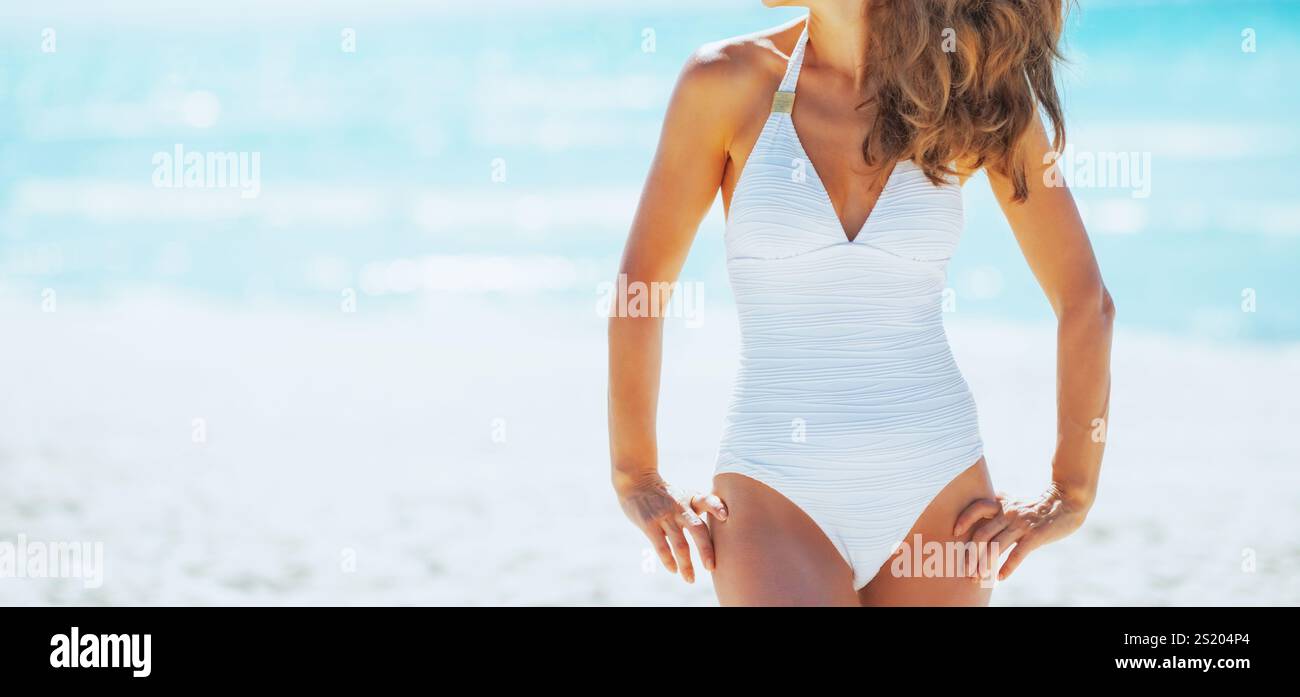 Junge Frau mit Sonnenbrille am Strand mit Blick auf Textfreiraum Stockfoto