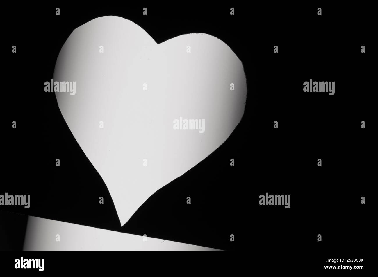 Herz aus schwarzem Papier ausgeschnitten Stockfoto