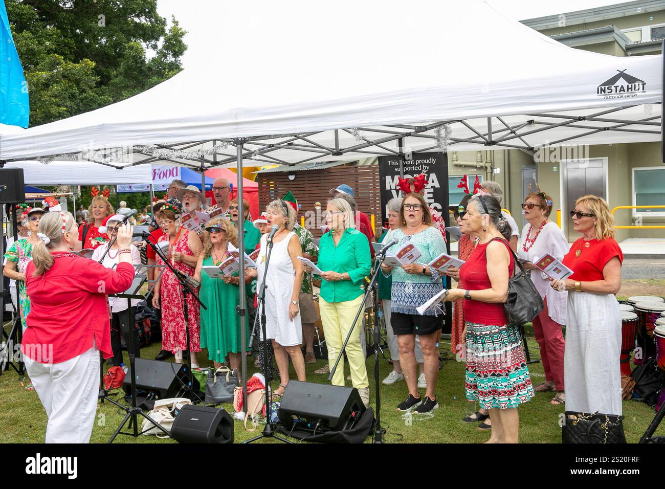 Seniorenchor singt weihnachtslieder auf einem lokalen weihnachtsmarkt in Avalon Beach, Sydney, Australien Stockfoto