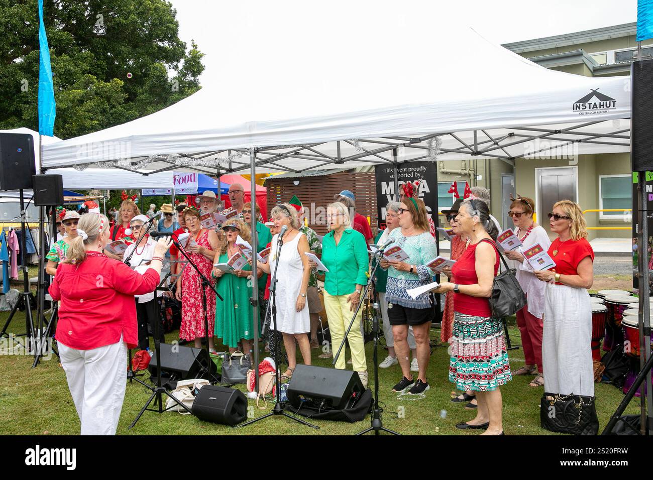 Seniorenchor singt weihnachtslieder auf einem lokalen weihnachtsmarkt in Avalon Beach, Sydney, Australien Stockfoto