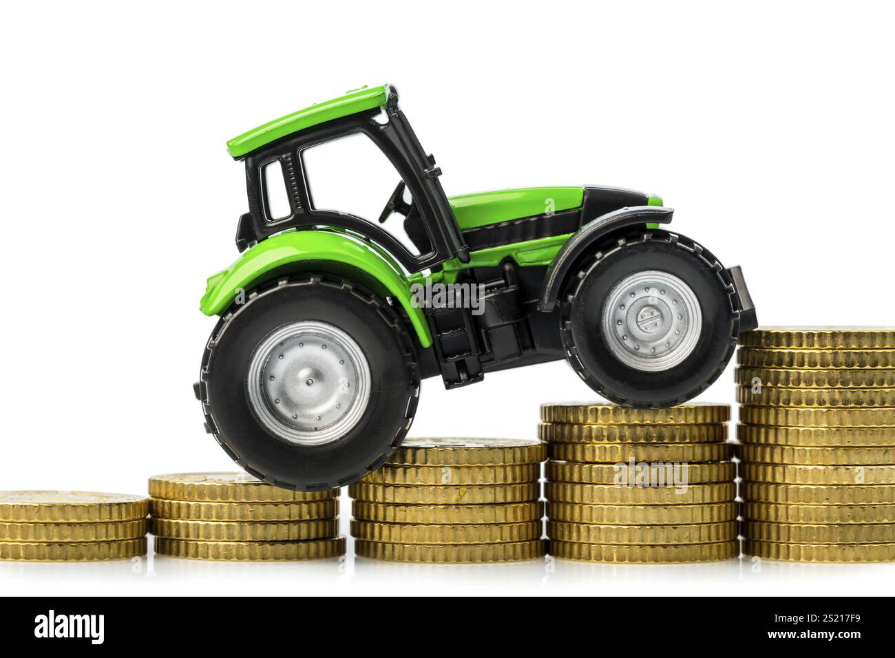 Die Landwirte in der Landwirtschaft müssen mit steigenden Kosten rechnen. Höhere Preise für Futtermittel, Düngemittel und Pflanzen. Traktor mit Münzen Stockfoto