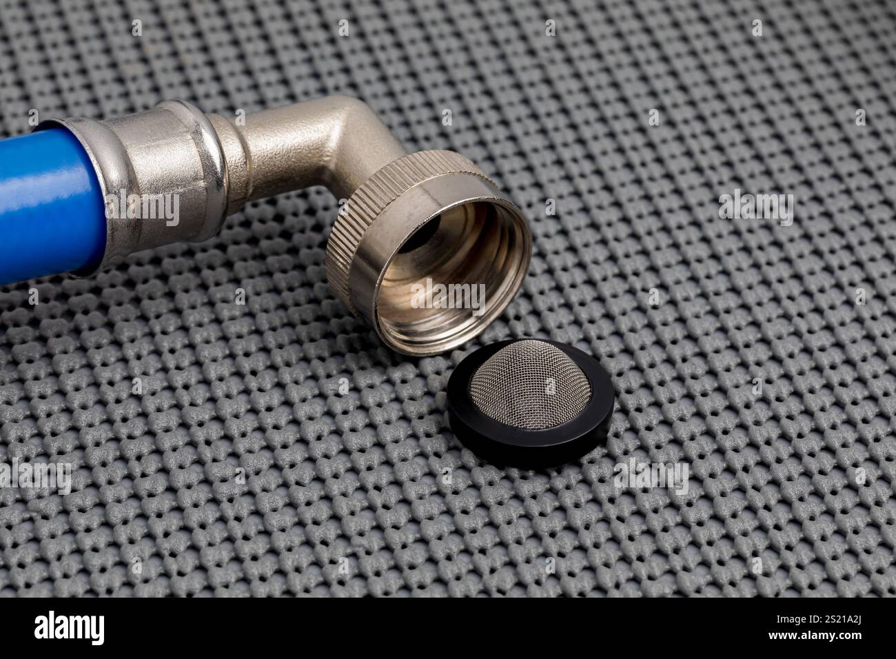 Waschmaschinenschlauch mit Filtersieb. Konzept für Hauswartung, Sanitär- und Gerätereparatur. Stockfoto