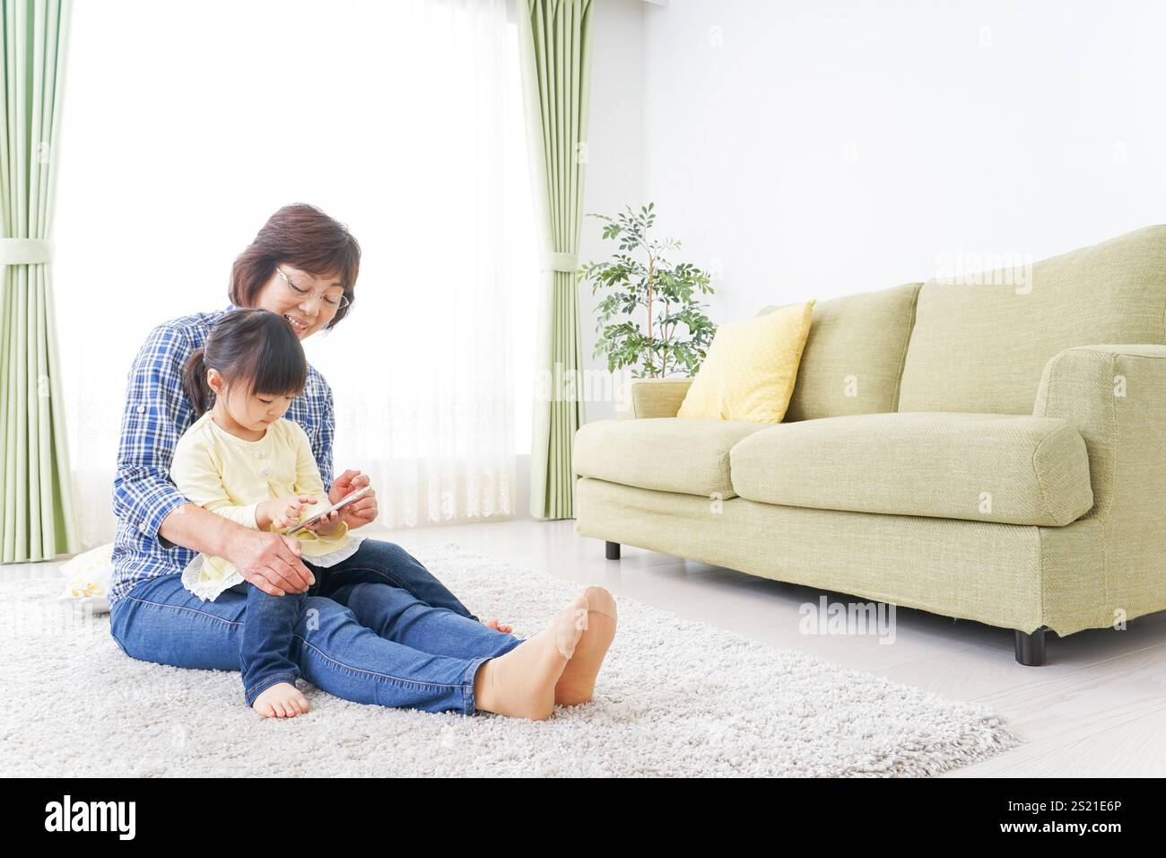 Kind, das ein Telefon mit Oma benutzt Stockfoto