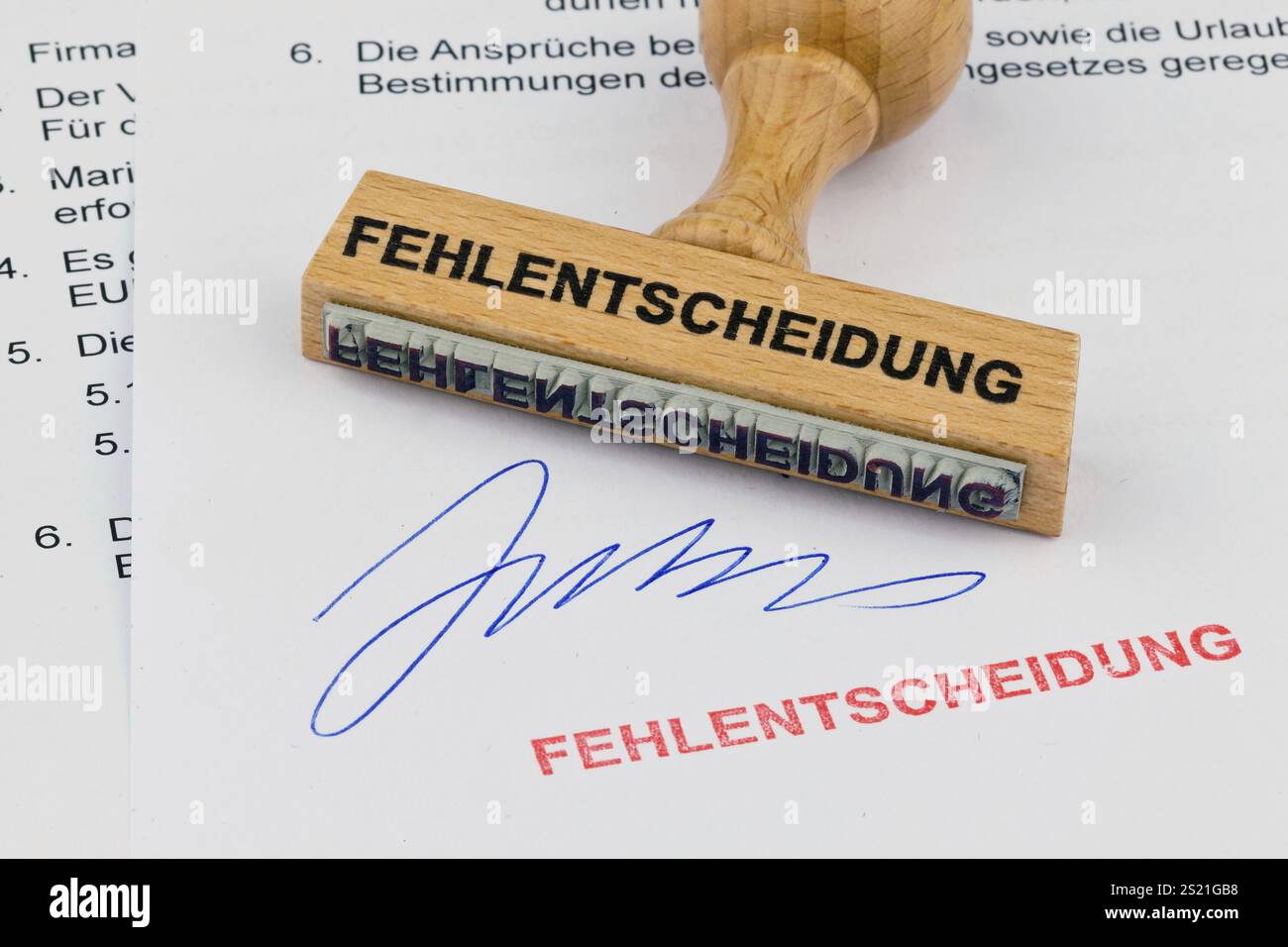 Ein Holzstempel liegt auf einem Dokument. Inschrift falsche Entscheidung Österreich Stockfoto
