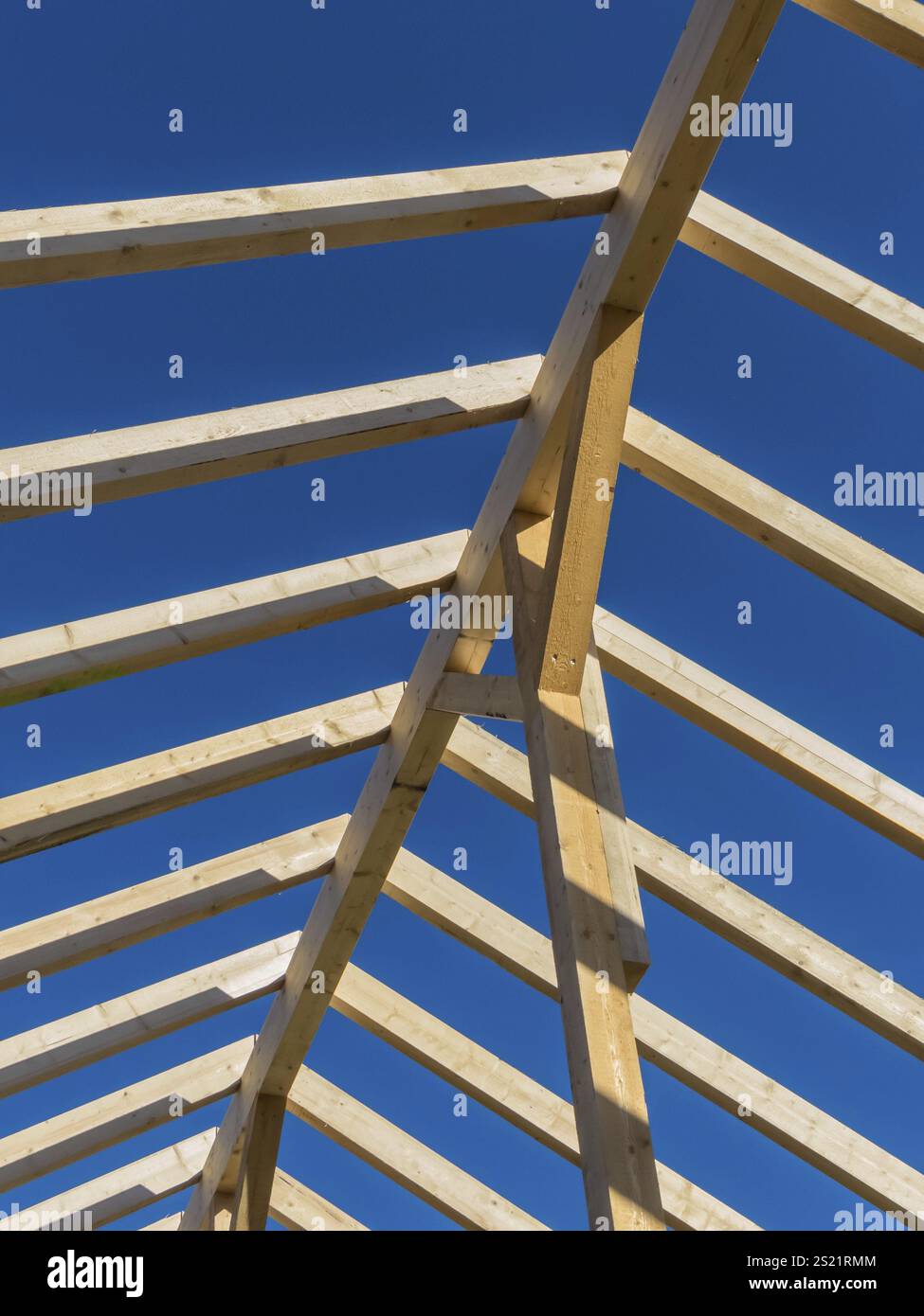 Ein neues Dach wird auf einem Haus auf einer Baustelle errichtet. Holzbalken für den Dachbinder. Österreich Stockfoto