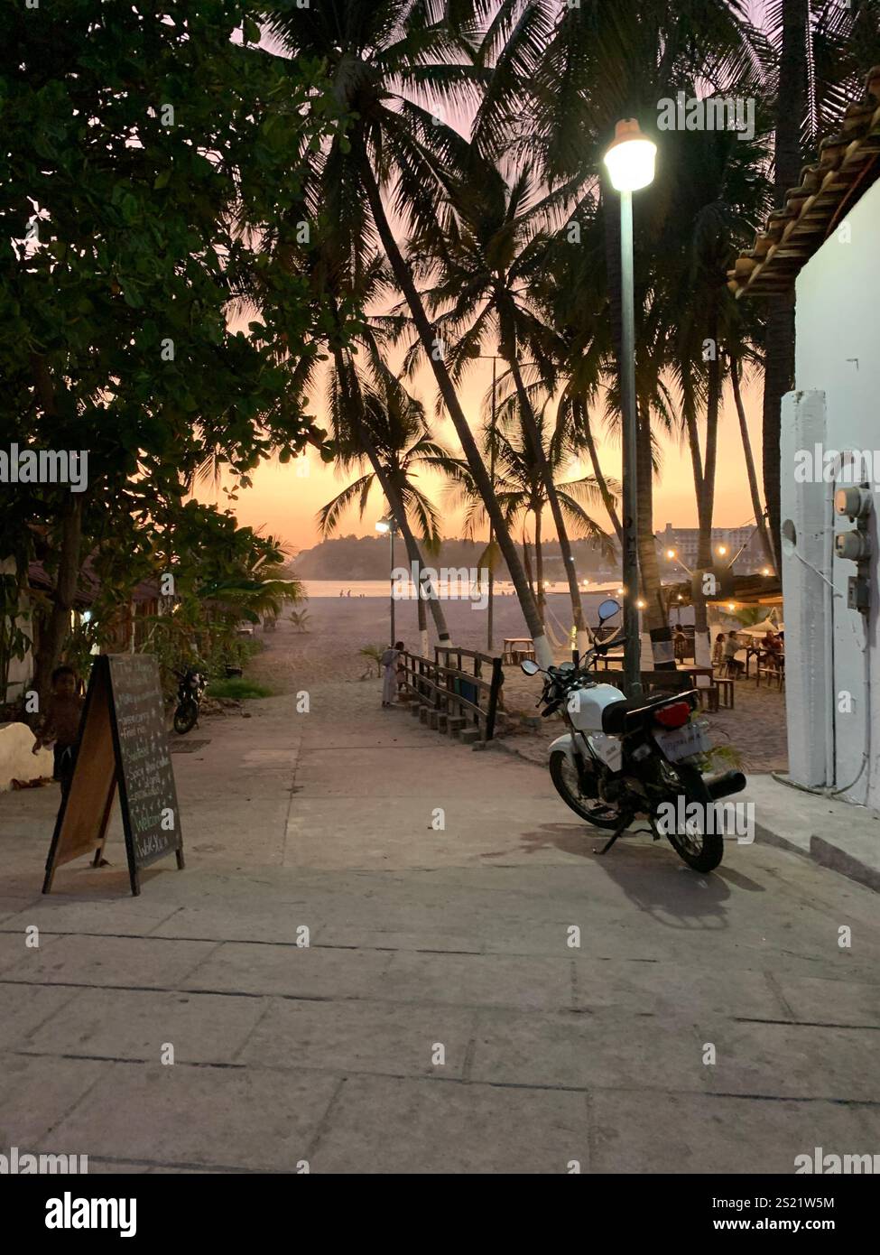Sonnenuntergang Boho Vibes am Strand mit Palmen - Smartphone-aufgenommenes Stockfoto