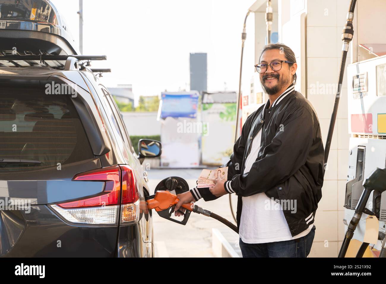 Tanken eines Autos mit einer Tankstellenpumpe. Auto betankt an der Tankstelle. Tanken Sie Benzin auf. Kraftstoffpumpe füllt Kraftstoffdüse ein Stockfoto
