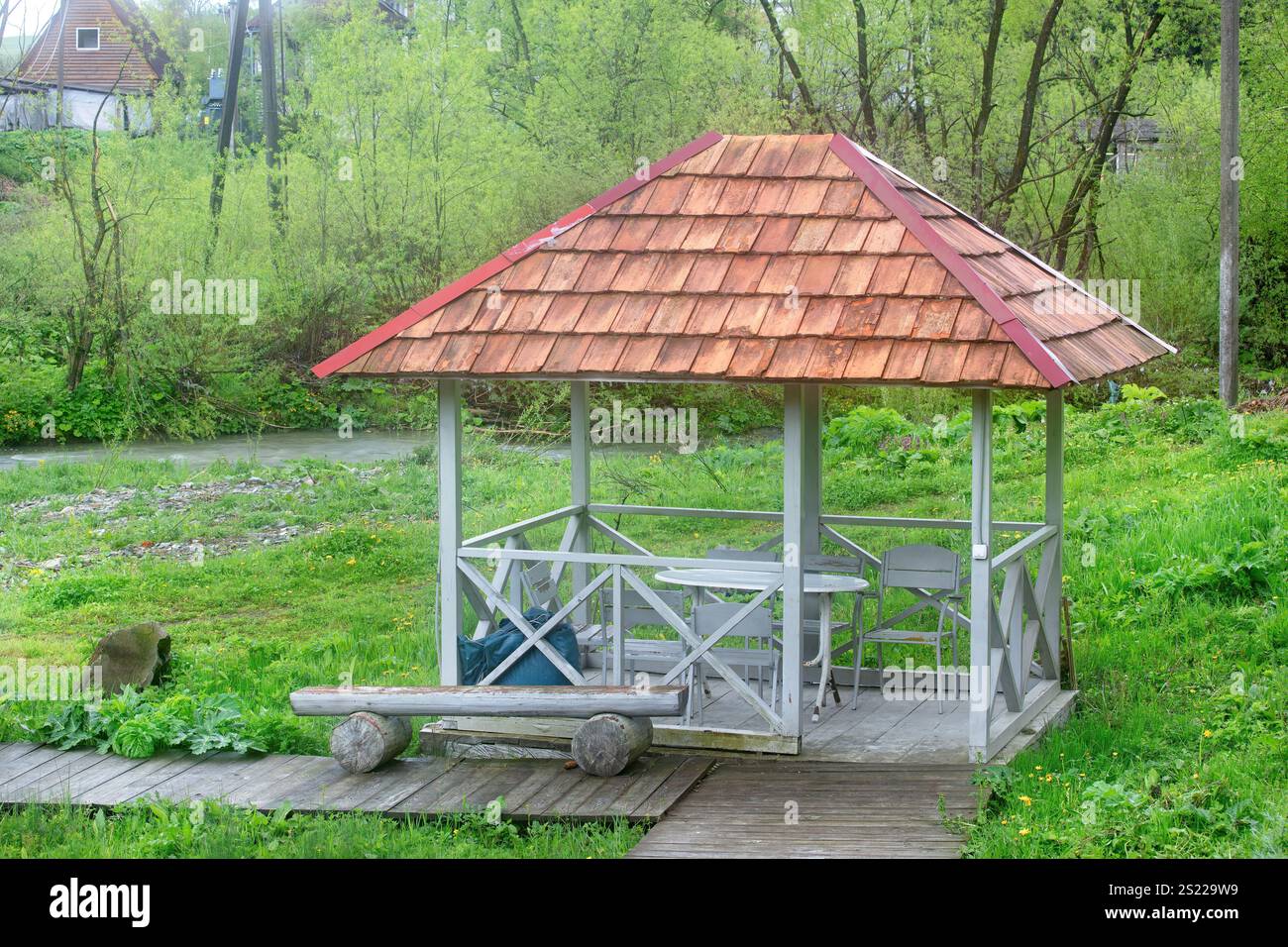 Der malerische hölzerne Pavillon liegt an einem sanft fließenden Fluss und bietet einen perfekten Rückzugsort. Stockfoto