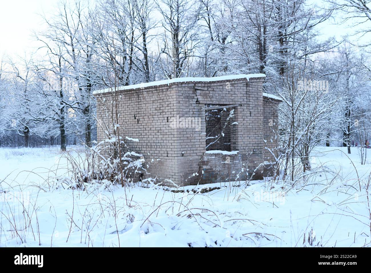 Ein verlassenes Gebäude vor einer wunderschönen Winterlandschaft, das ein tiefes Gefühl von Nostalgie weckt Stockfoto