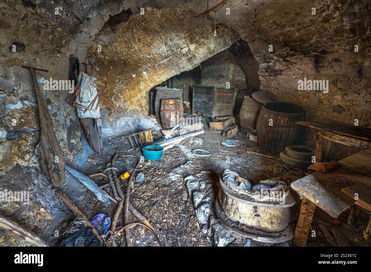 Ein alter Keller in den Felsen gegraben mit verlassenen Objekten im mittelalterlichen Dorf Acciano. Regionaler Naturpark Sirente Velino, Abruzzen, Italien Stockfoto