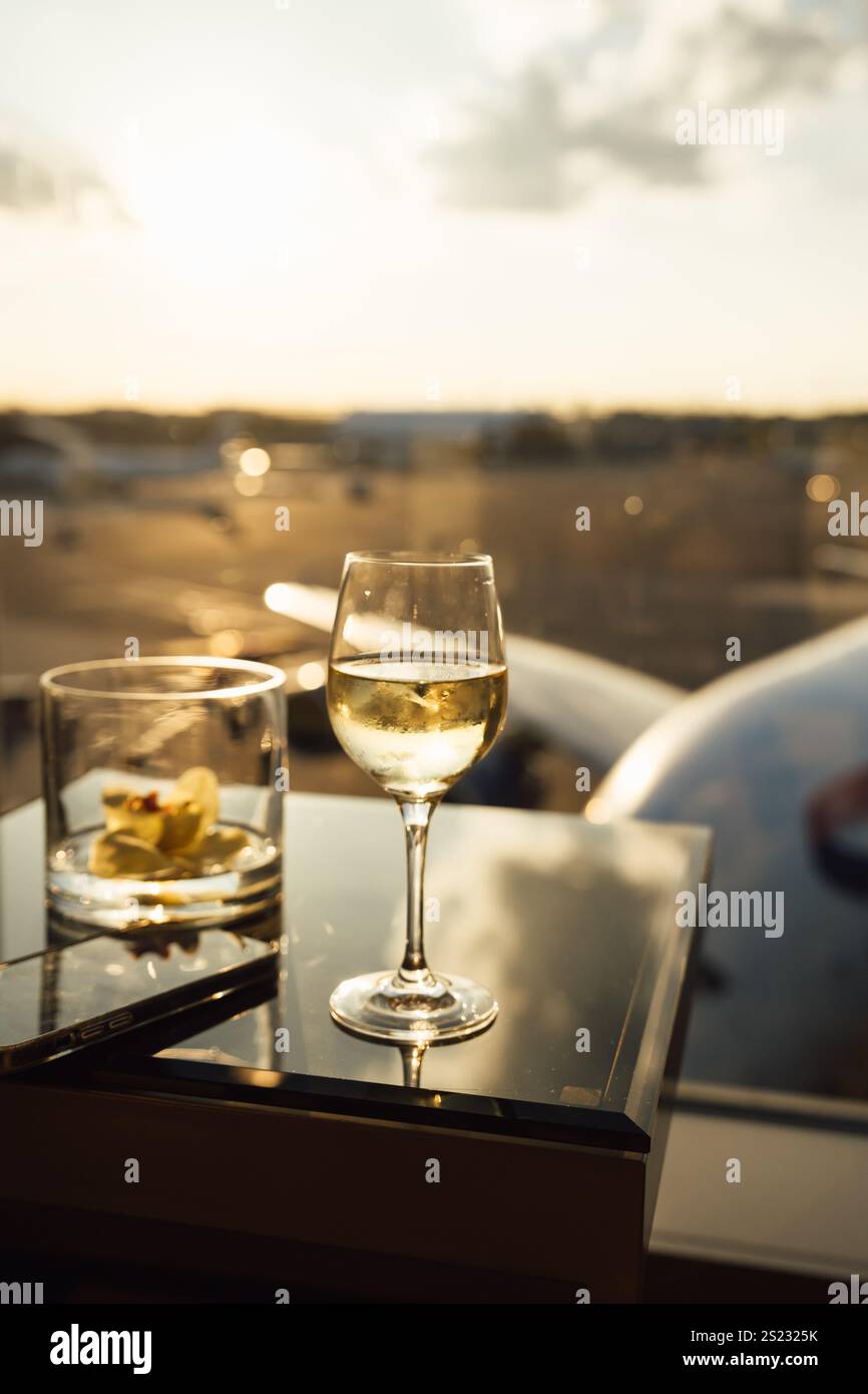Foto von einem Glas Weißwein und leerem Bourbonglas am Flughafen Stockfoto