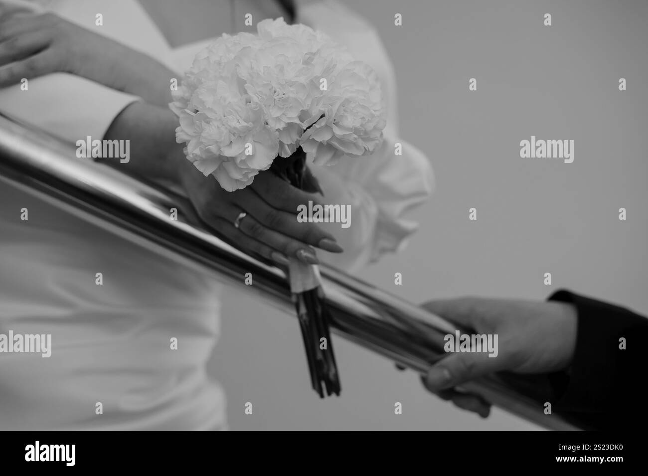 Elegante Braut mit weißen Blumen in romantischer Umgebung. Stockfoto