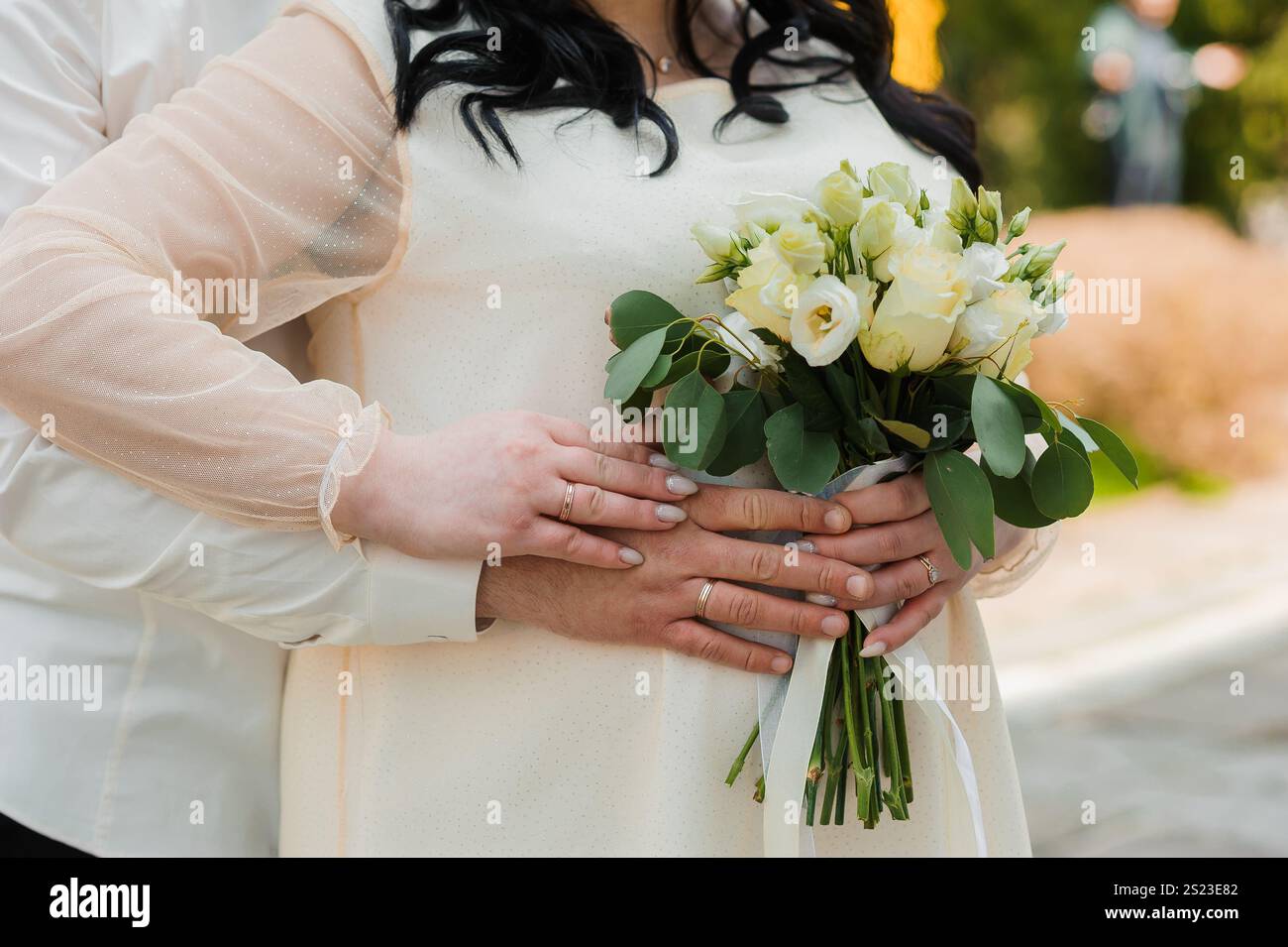 Intime Hochzeitsmomente mit einem Paar, das Bouquet umschließt und hält. Stockfoto