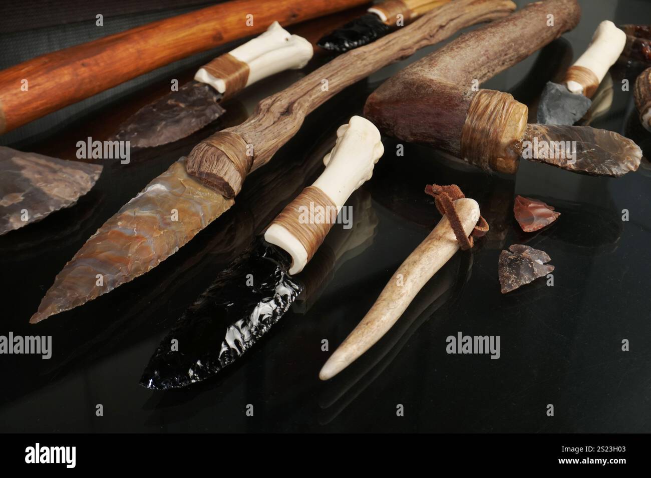 Steinzeitwerkzeuge mit Messern, schwarzer Hintergrund Stockfoto