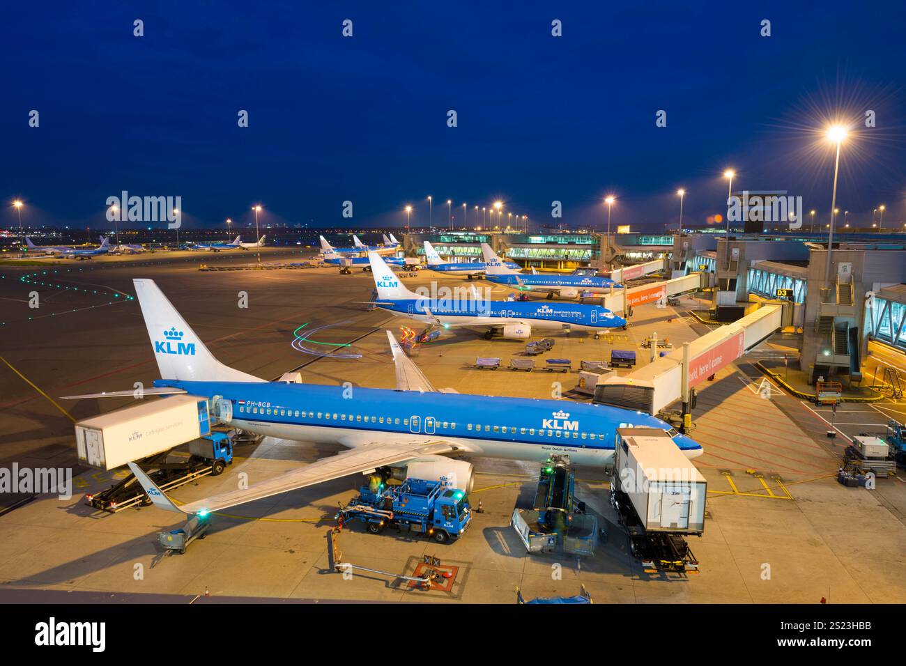Schiphol, Niederlande - Amsterdam Flughafen Schiphol (Luchthaven Schiphol) bei Nacht. Vor den Blocks eine Boeing 737 von KL Stockfoto