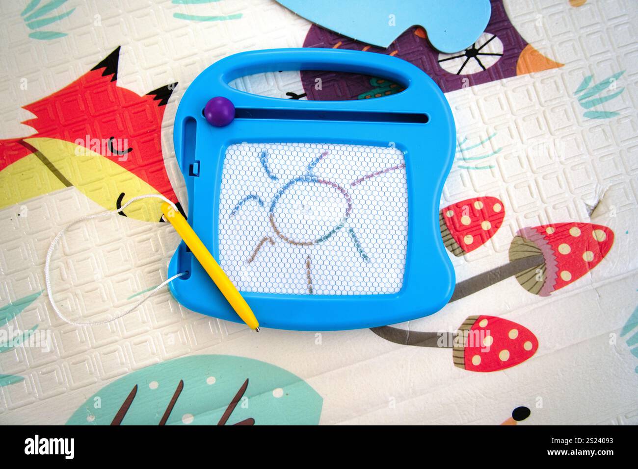 Magnetisches Zeichenbrett auf Kinderspielmatte mit Sonnenzeichnung Stockfoto