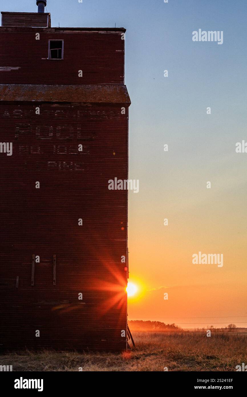 Ein rotes Backsteingebäude mit einem großen Fenster und einem Schild mit der Aufschrift „Luce“. Die Sonne untergeht hinter dem Gebäude und strahlt ein warmes Licht auf die Szene Stockfoto Ein rotes Backsteingebäude mit einem großen Fenster und einem Schild mit der Aufschrift „Luce“. Die Sonne untergeht hinter dem Gebäude und strahlt ein warmes Licht auf die Szene Stockfoto