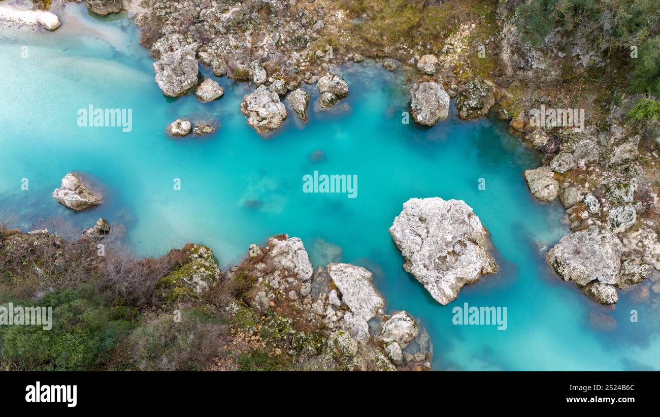Ein türkisfarbener Fluss schlängelt sich durch felsiges Gelände, umgeben von üppiger Wildnis in Albanien. Stockfoto