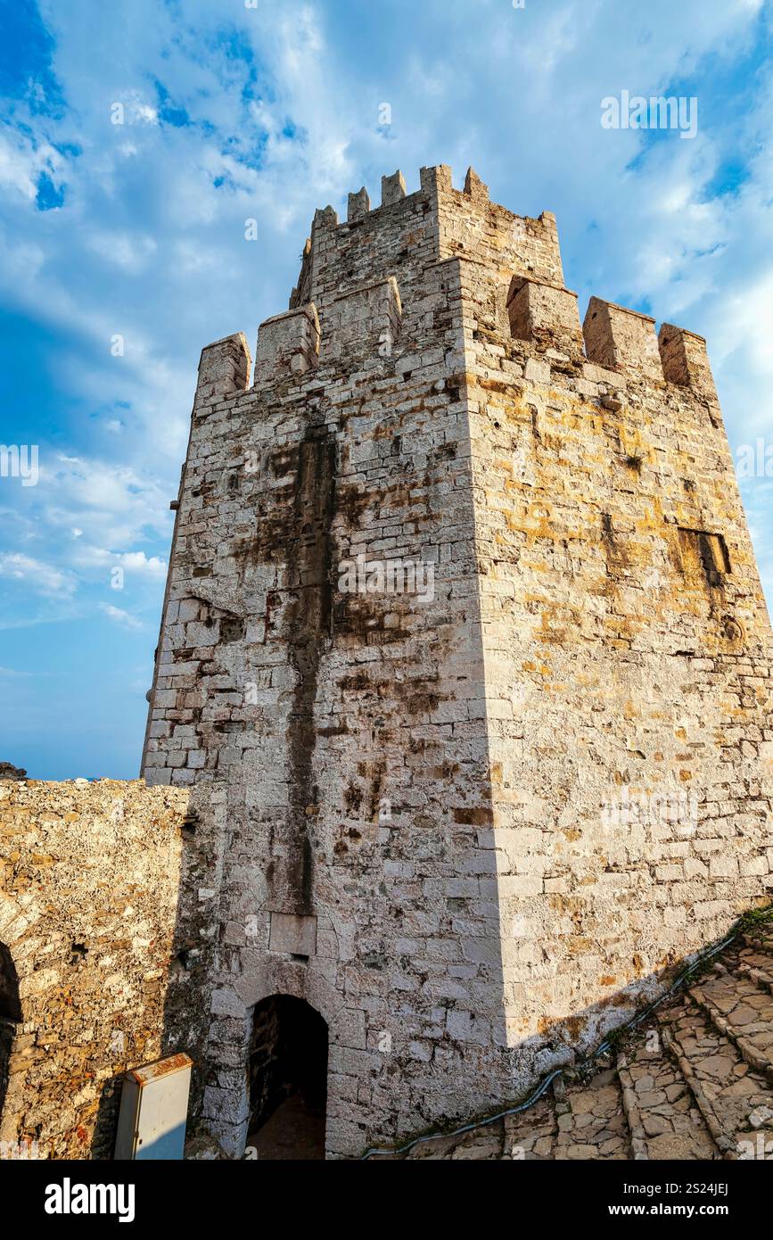 Aus nächster Nähe sehen Sie einen hohen Steinturm in der Festung Methoni, der die mittelalterliche venezianische Architektur und das verwitterte Mauerwerk unter der Nachmittagssonne hervorhebt Stockfoto