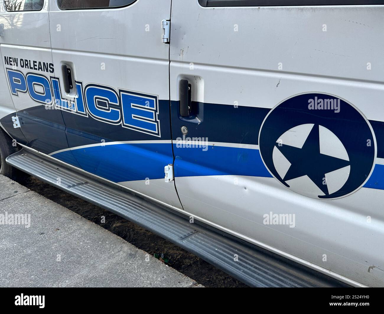 New Orleans, Louisiana, USA - 23. Dezember 2024: Ein Stern und ein Mondsichel-Logo des New Orleans Police Department (NOPD) sind auf einem geparkten Fahrzeug zu sehen. - Smartphone-aufgenommenes Stockfoto
