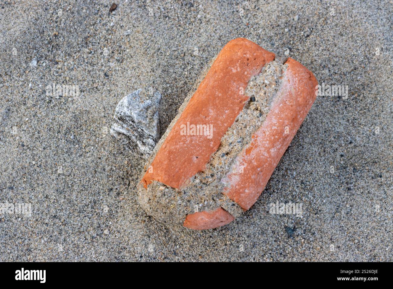 Die Schönheit eines alten Ziegels, der während der Flut aus dem Meer gespült wurde. Abgerundete Kanten aus der Kraft des Meeres. Strand des Tyrrhenischen Meeres, Sizilien, Italien. Stockfoto