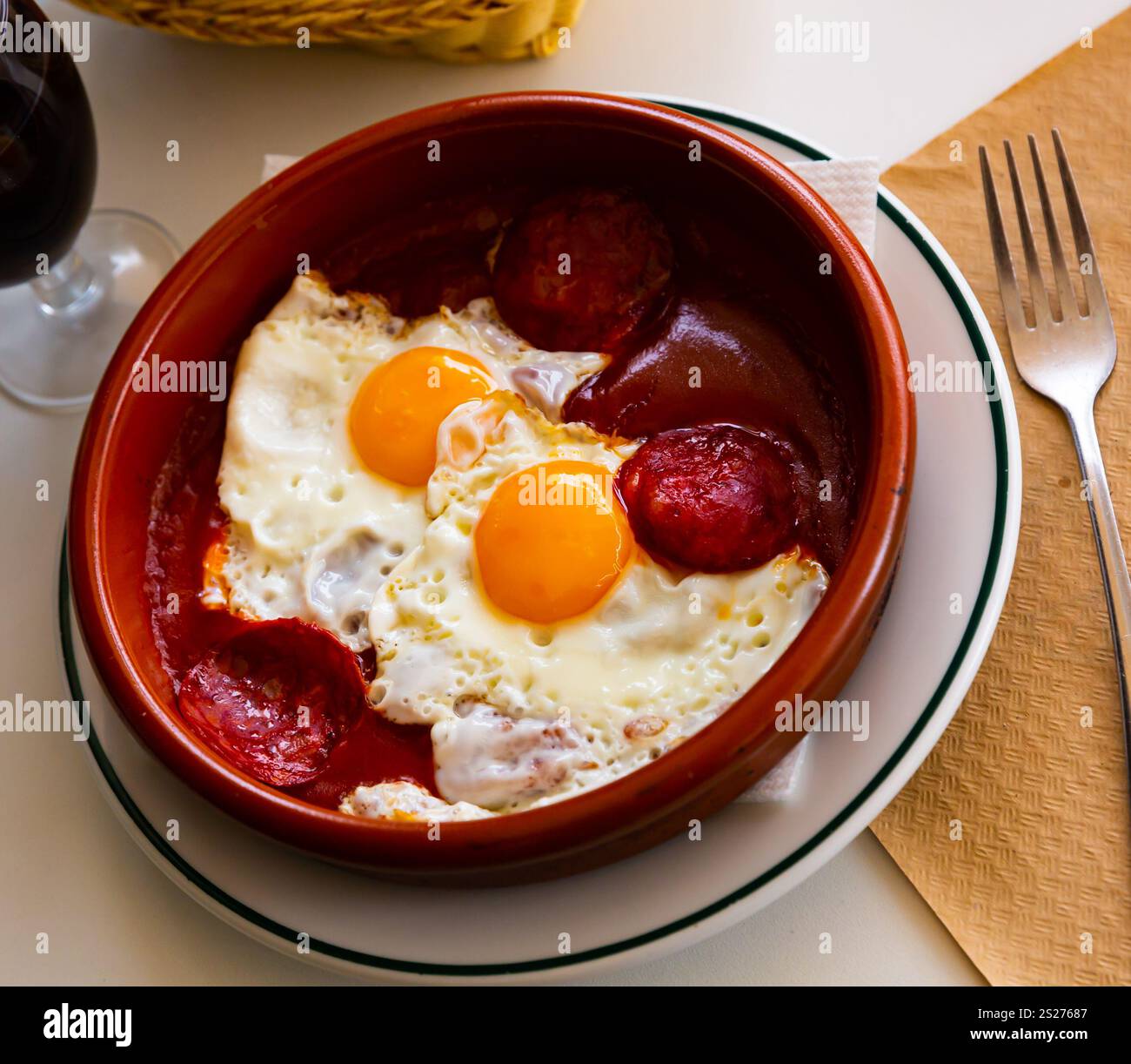 Beliebtes spanisches Gericht, Spiegeleier mit Chorizo-Würstchen und Tomatenpaste auf Teller Stockfoto