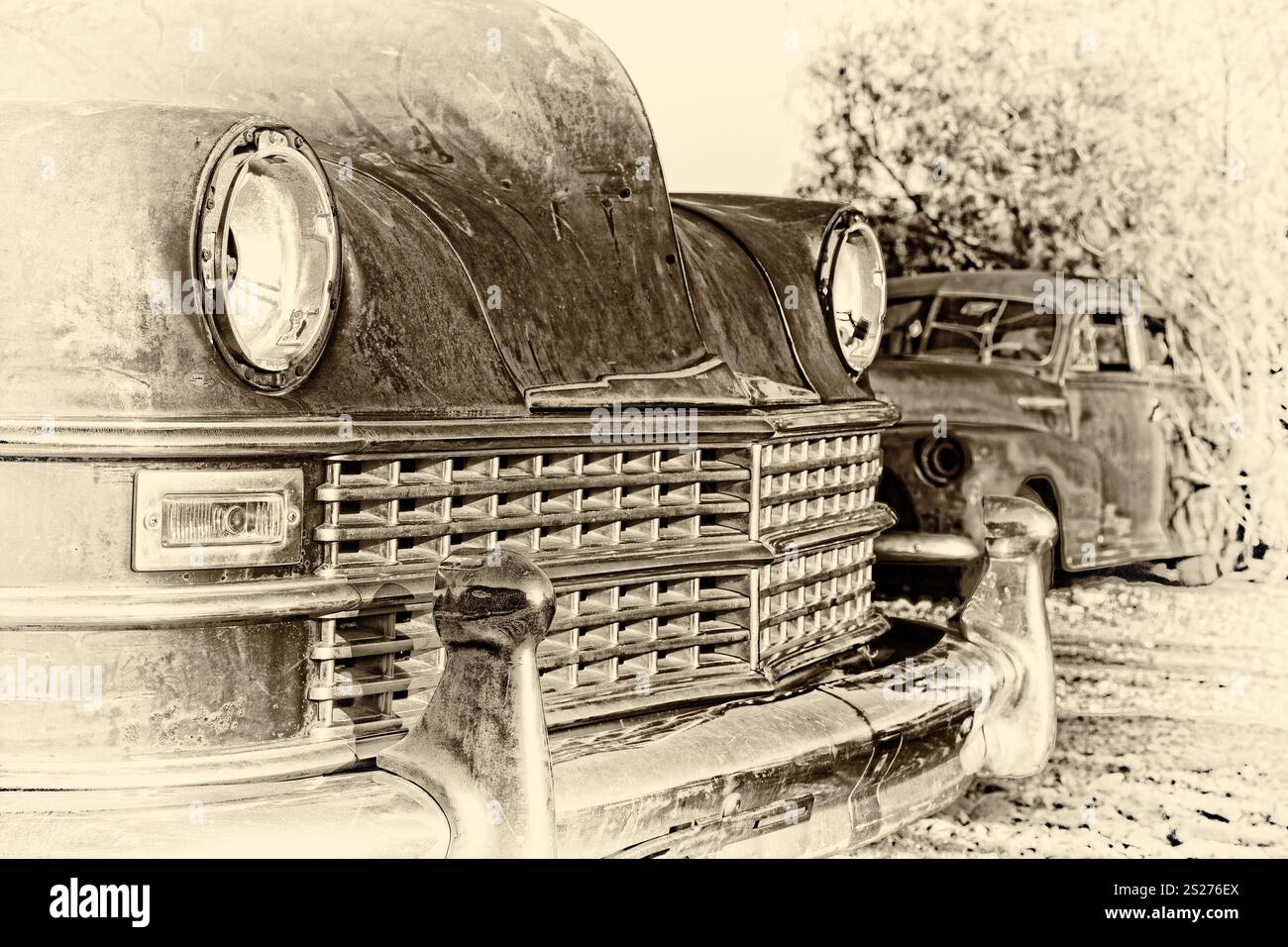 Ein altes Auto steht neben einem anderen alten Auto. Das Auto ist schmutzig und hat ein verblasstes Aussehen. Die Szene ist ruhig und friedlich, und niemand ist da Stockfoto