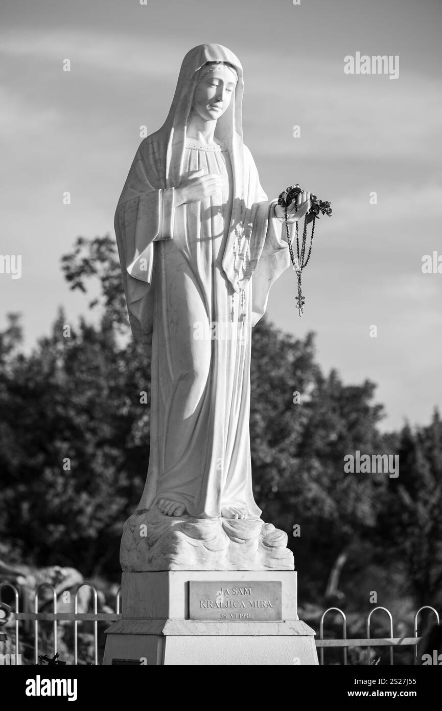 Statue der Jungfrau Maria – Königin des Friedens auf dem Berg Podbrdo, dem Hügel der Erscheinung mit Blick auf das Dorf Medjugorje in Bosnien und Herzegowina. Stockfoto