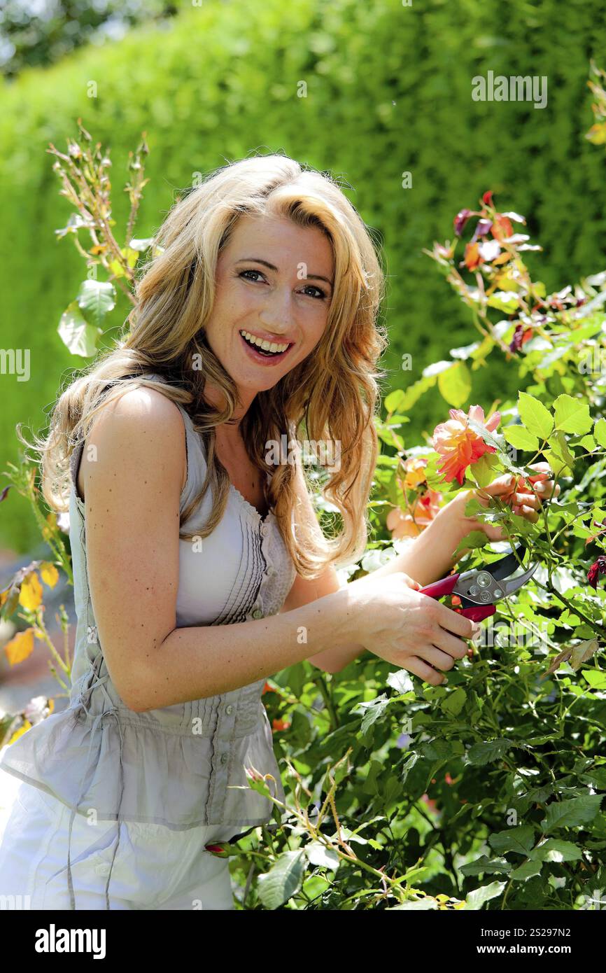 Frau mit Schere und Rose Stockfoto