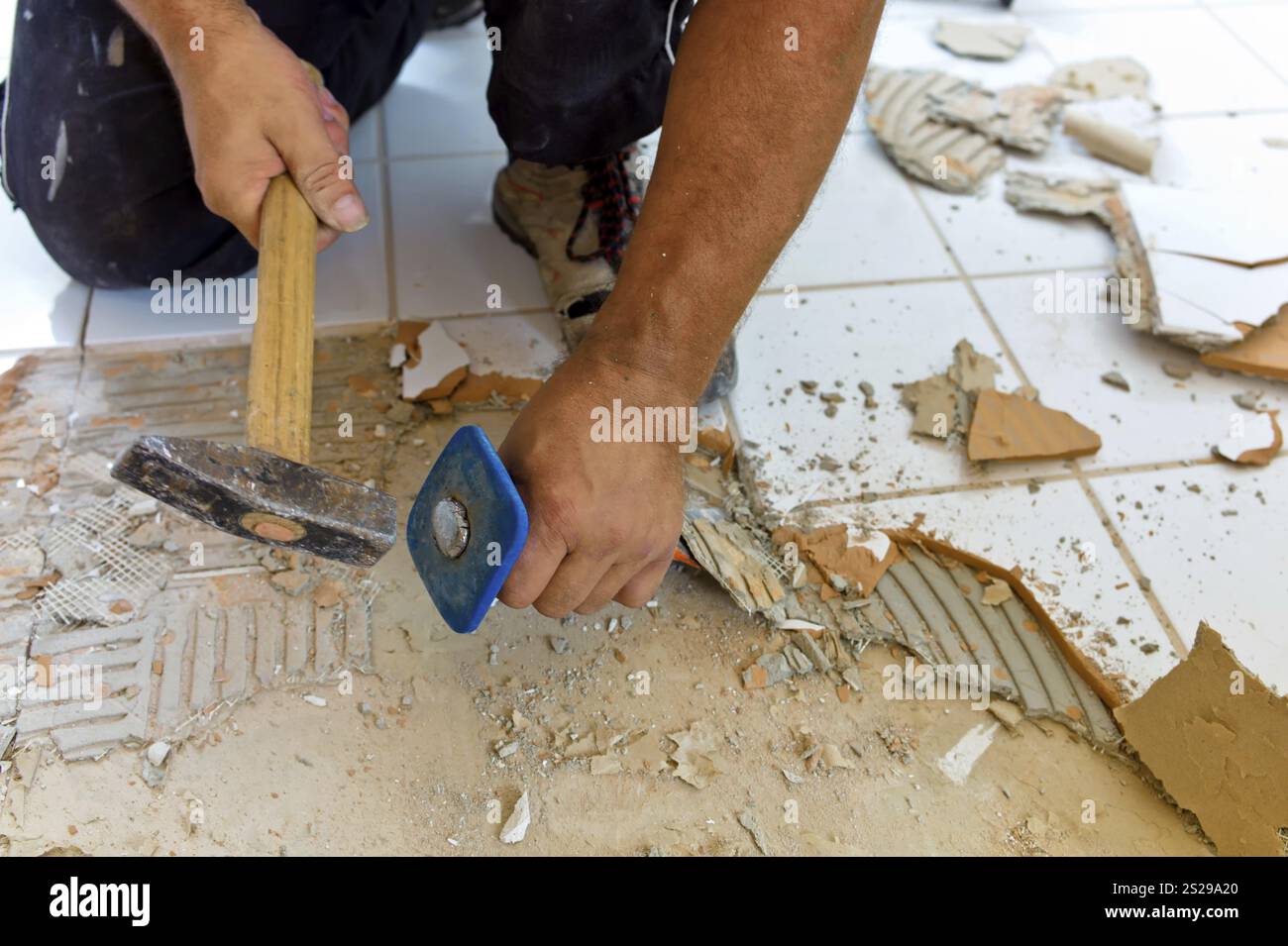 Kaputte Fliesen während der Renovierung eines Badezimmers. Umbau und Renovierung im Wohnbereich. Fliesen bei der Arbeit Stockfoto