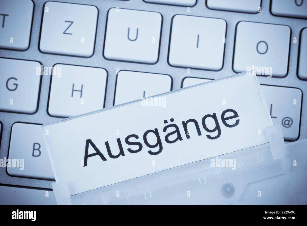 Ein Ordner für Dateien in einer hängenden Datei vor einer Computertastatur zum Thema: Beendet Österreich Stockfoto