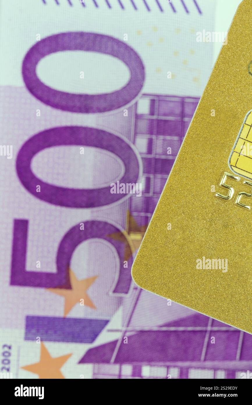 Eine goldene Kreditkarte und Euro-Banknoten. Symbolisches Foto für bargeldloses Einkaufen und Statussymbole. Österreich Stockfoto