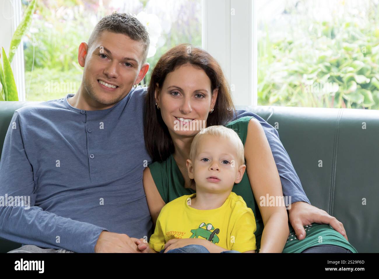 Eine junge Familie sitzt auf einer Couch Austria Stockfoto