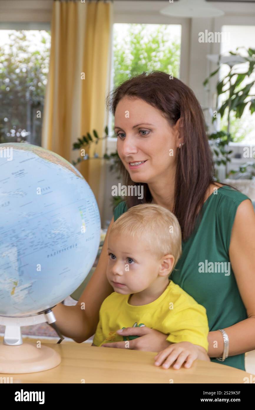 Eine Familie sitzt in einem Globus und plant eine Reise nach Österreich Stockfoto