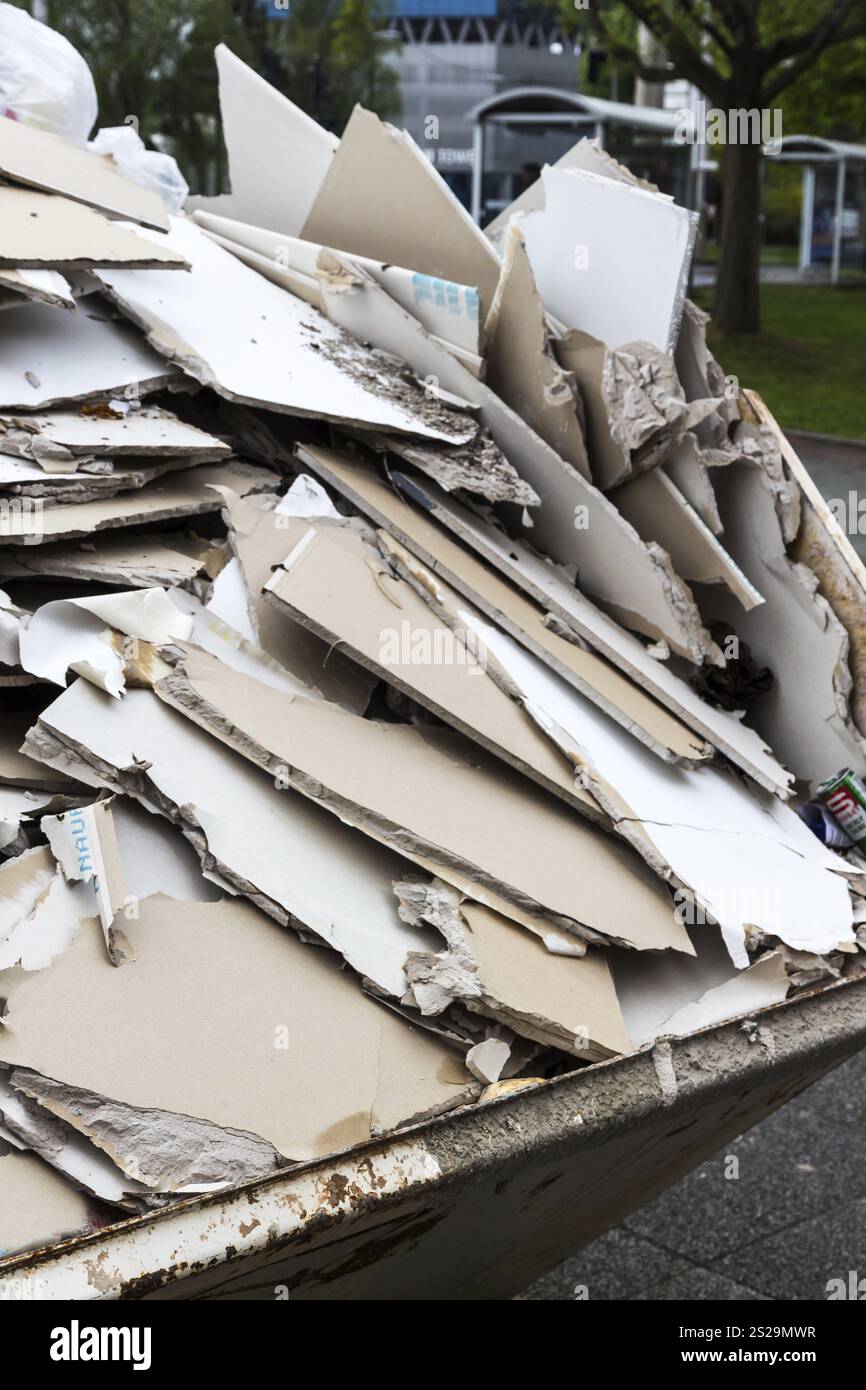 Gipskartonplatten werden in einem Abfallbehälter zur Entsorgung in Österreich gelagert Stockfoto