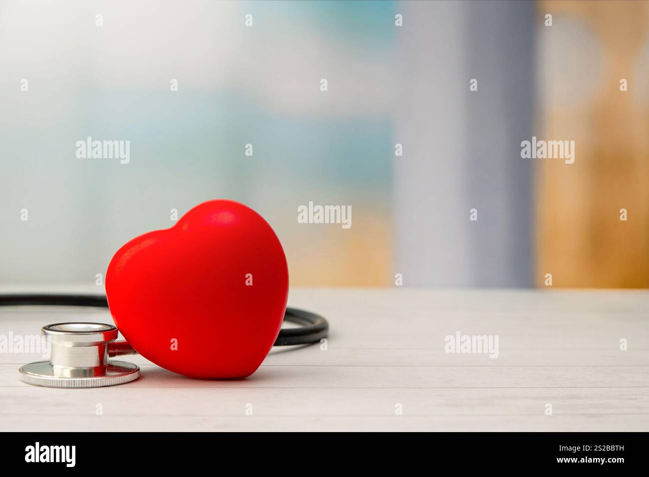 Eine Nahaufnahme eines roten Herzens und eines Stethoskops. Kopierbereich für Text. Medizin- und Gesundheitskonzept. Stockfoto