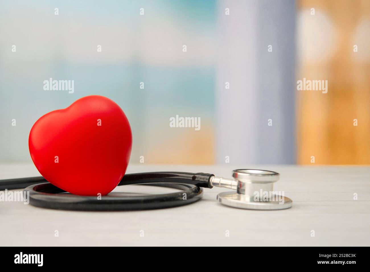 Eine Nahaufnahme eines roten Herzens und eines Stethoskops. Kopierbereich für Text. Medizin- und Gesundheitskonzept. Stockfoto