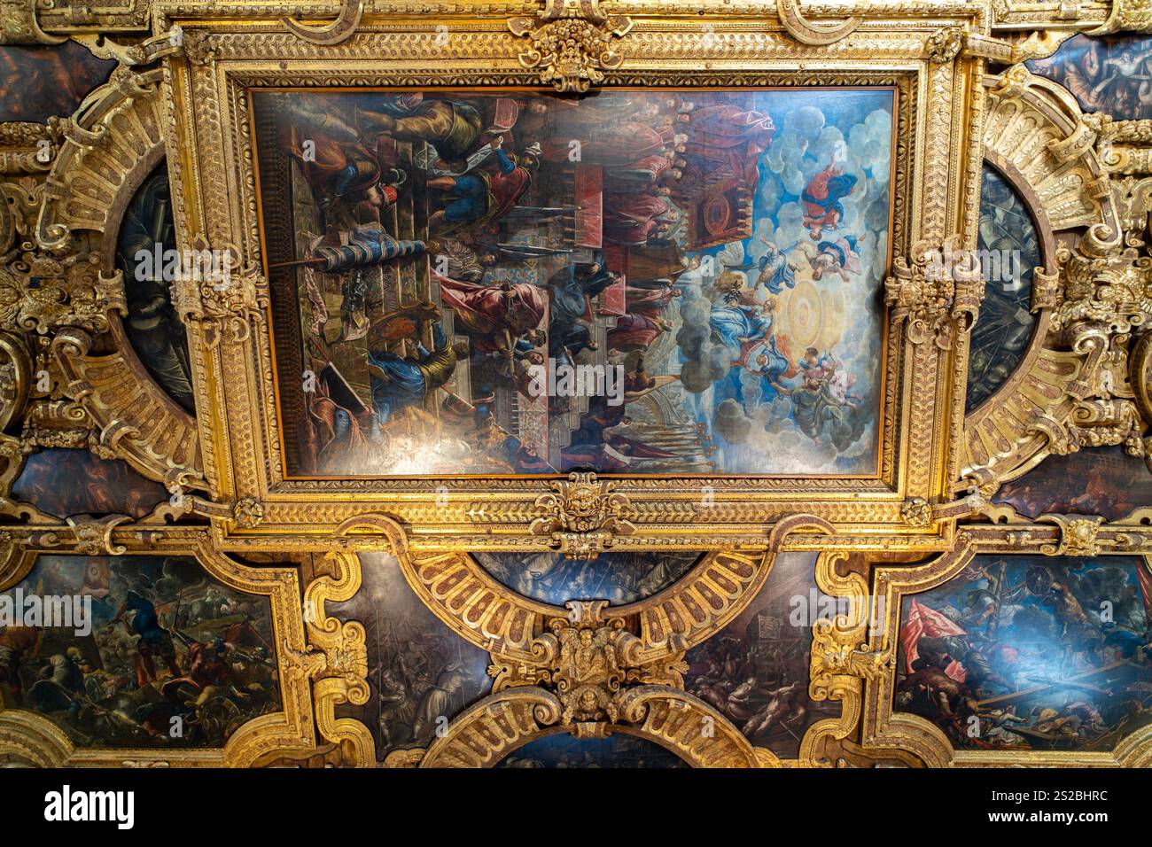 Eine aufwendige barocke Decke mit vergoldeten Rahmen und detaillierten Fresken, die mythologische und historische Szenen darstellen, in satten Farben und Stockfoto