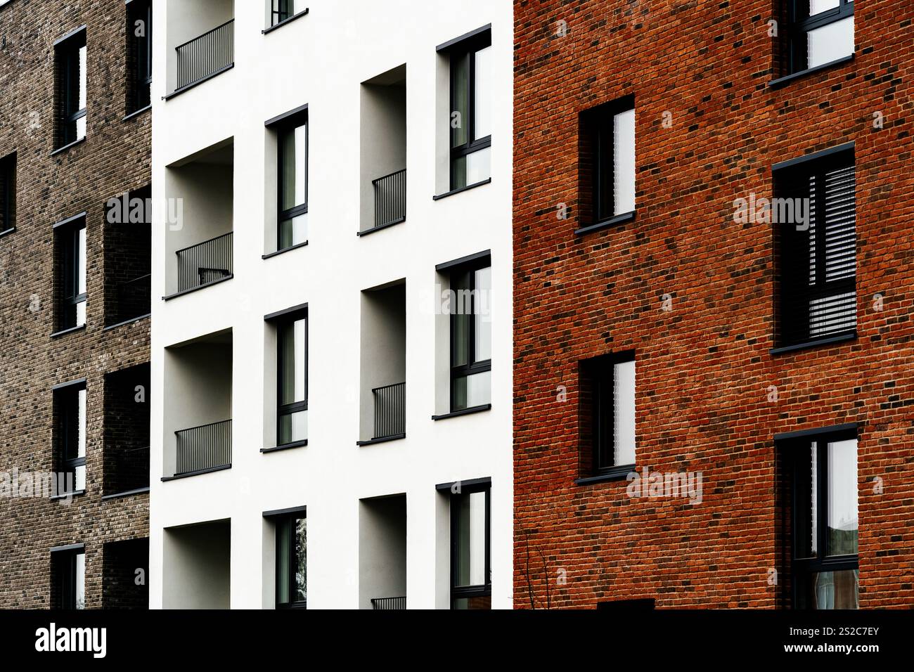Moderner Wohnkomplex mit gemischter Ziegelfassade und weißer Fassade, großen Fenstern und minimalistischem Design Stockfoto